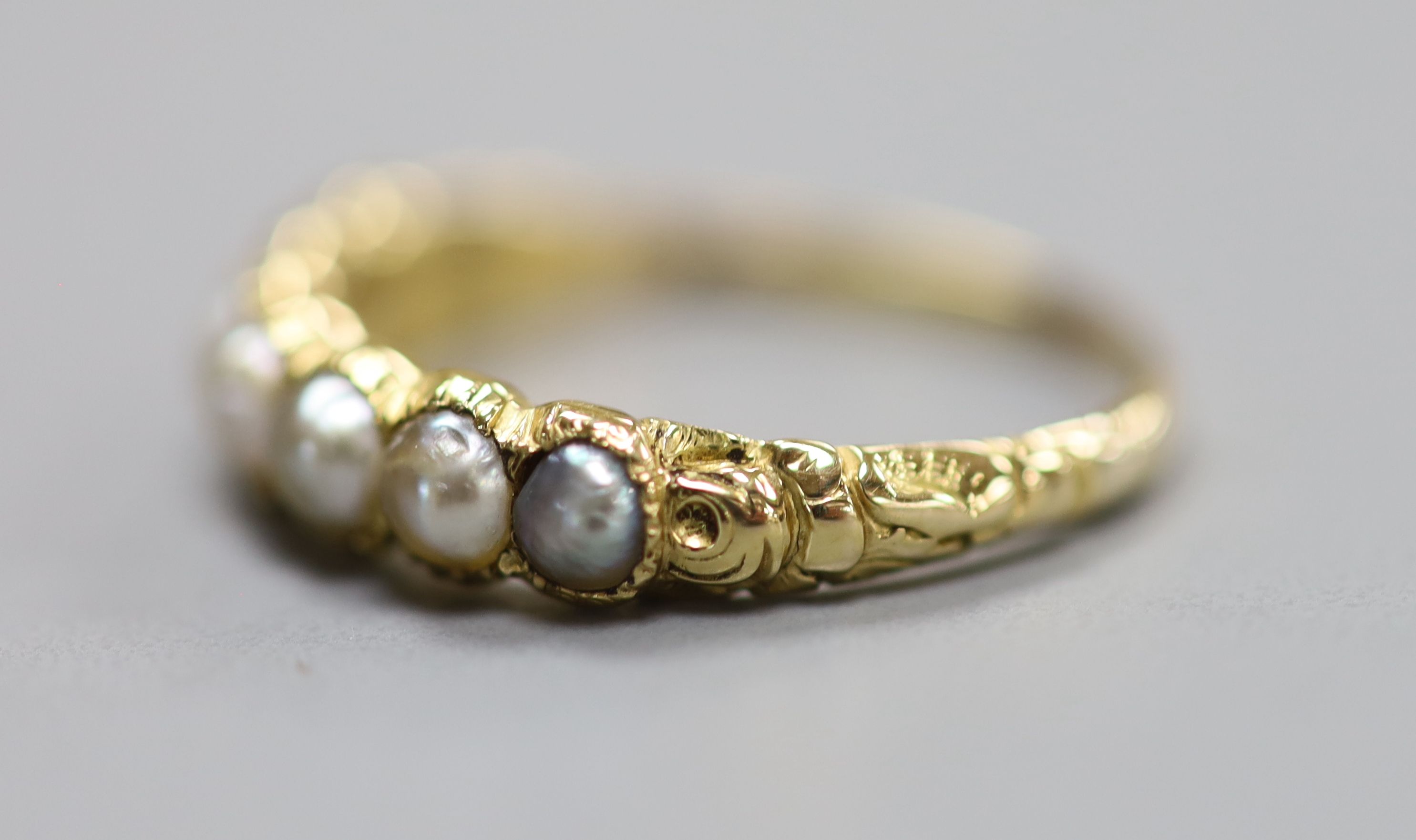 A late Victorian yellow metal and split pearl set half hoop ring